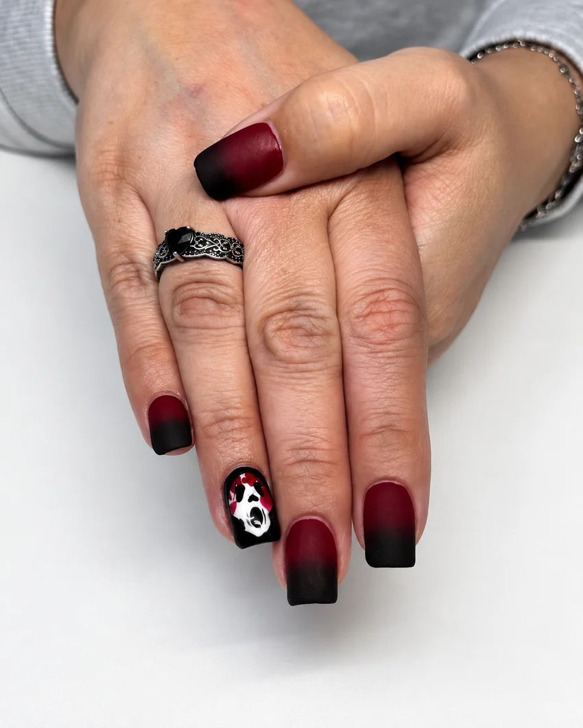 Matte burgundy-to-black ombré manicure with a ghost accent nail